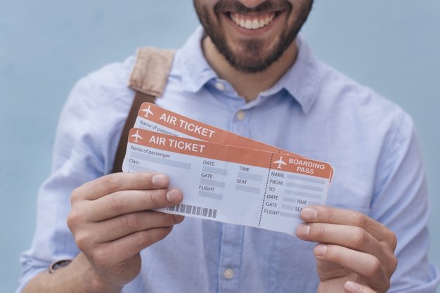 close up smiling man showing air ticket